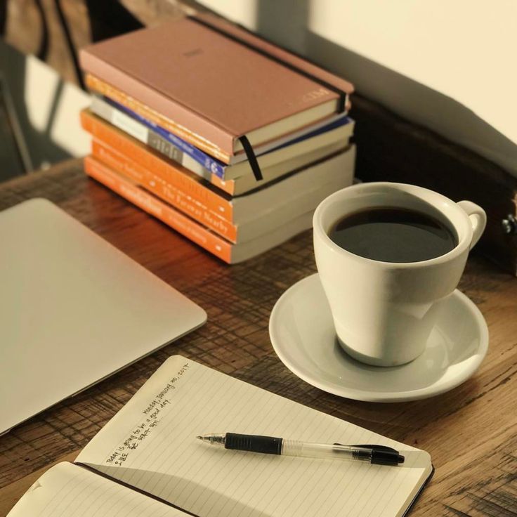Quiet ceramic mug beside open notebook bathed in gentle daylight indoors